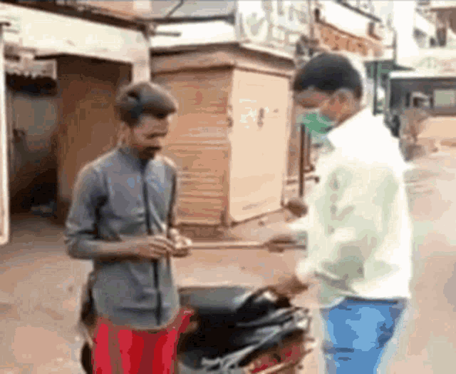a man wearing a mask is talking to another man on a street