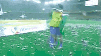 a soccer player in a yellow jersey is holding a green flag on a soccer field