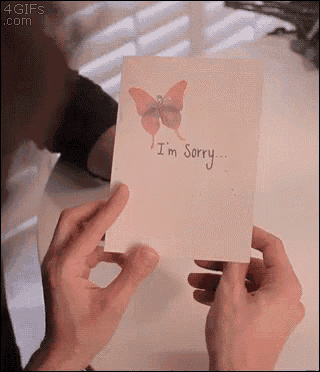 a person is holding up a card that says i 'm sorry