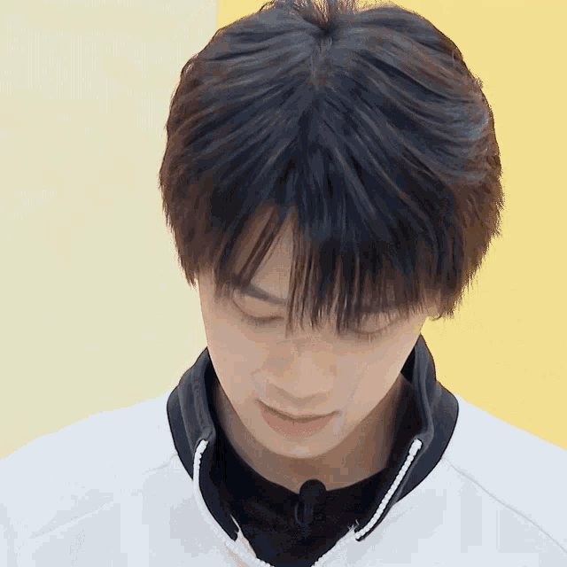 a close up of a person 's face with a white jacket on