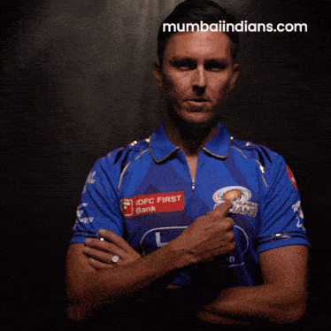 a man is wearing a blue shirt with idfc first bank on it