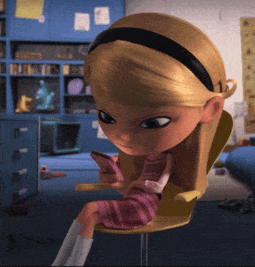 a girl in a pink dress is sitting in a chair looking at her phone