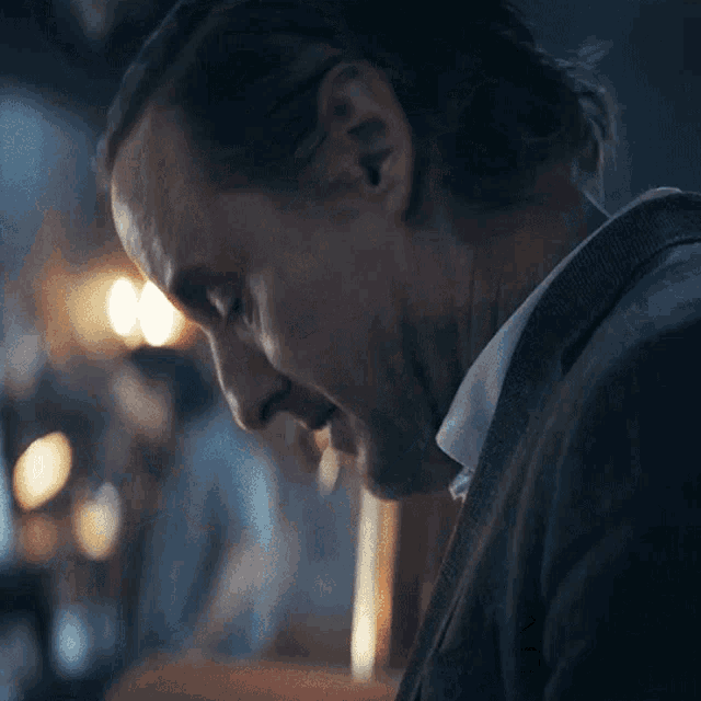 a man in a suit says " sorry " in front of his face
