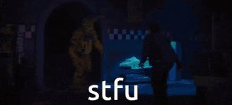 a person is walking in a dark room with the word stfu on the bottom of the image