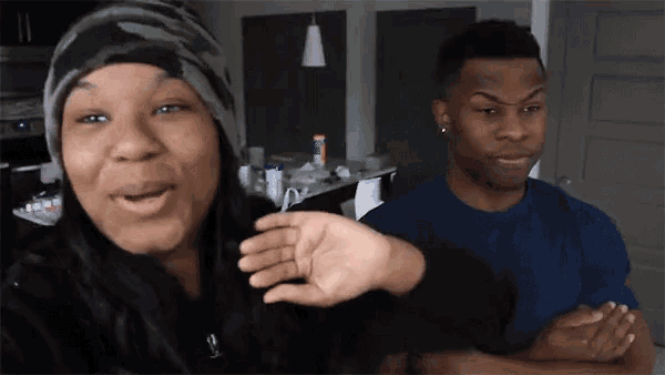 a man and a woman are standing next to each other and the woman is wearing a beanie