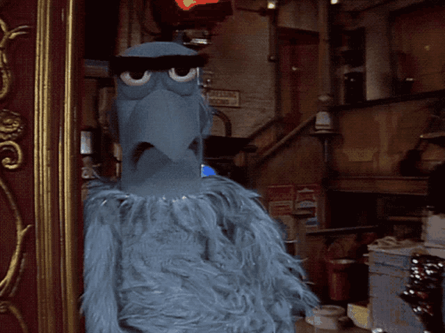 a sesame street character is standing in front of a sign that says ' emergency exit '