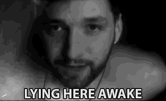 a man with a beard is laying here awake in a black and white photo