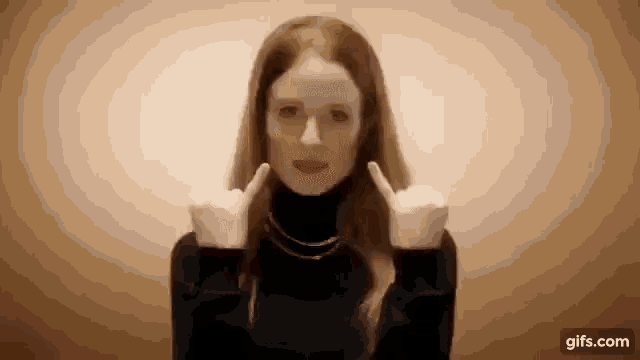 a woman in a black turtleneck is making a middle finger sign .
