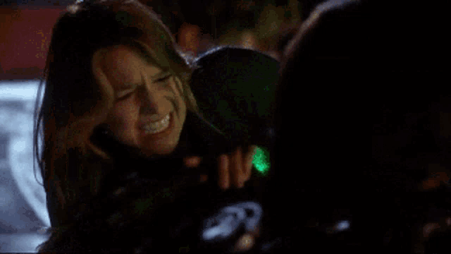 a woman is holding a green light behind her face