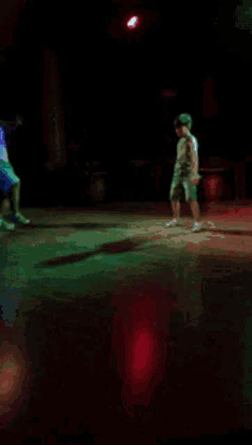 a man is dancing on a dance floor in a dark room