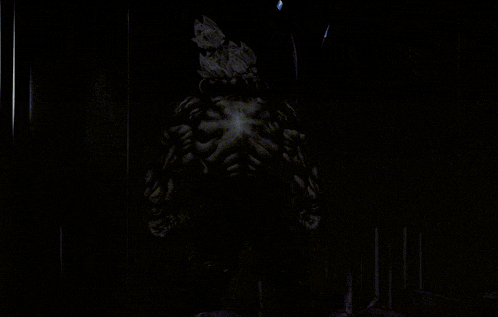 a silhouette of a monster in a dark room with a light shining on it