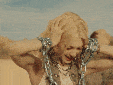 a close up of a woman 's face with chains around her wrists