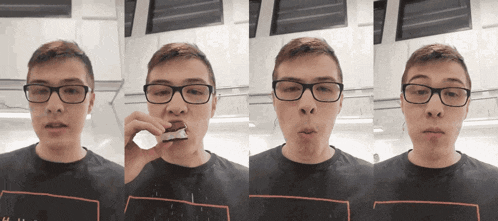 a young man wearing glasses and a black shirt with a red stripe on the bottom is eating something