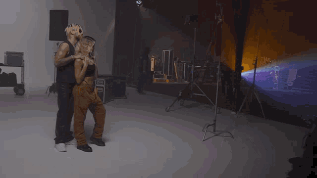 a man and a woman are dancing in a room with a box that says ' a ' on it