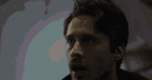a close up of a man 's face with a shocked look on his face