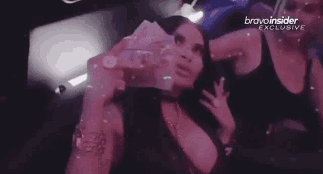 a woman is holding a bunch of money in her hand in a nightclub .