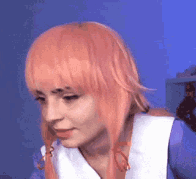 a woman with pink hair and pigtails is wearing a wig and a blue shirt .