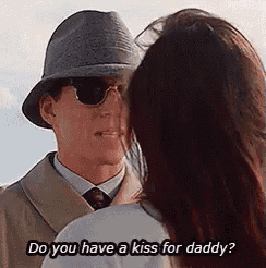 a man in a hat and sunglasses is asking a woman do you have a kiss for daddy