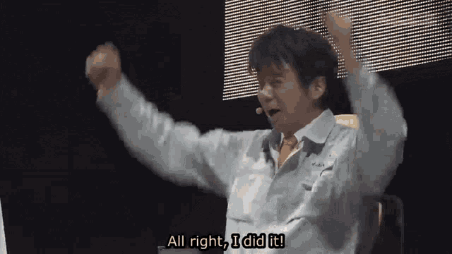 a man says " all right i did it " while raising his arms in the air