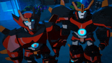 two transformers are standing next to each other and one has a transformer logo on the chest