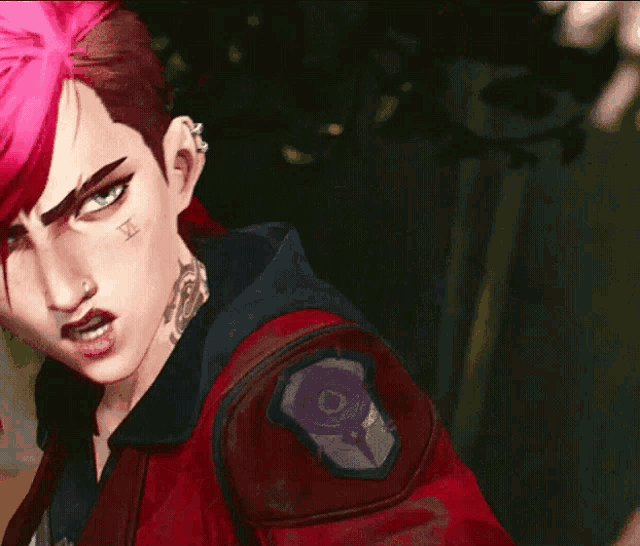 a woman with pink hair and a tattoo on her face is pointing her finger at the camera .