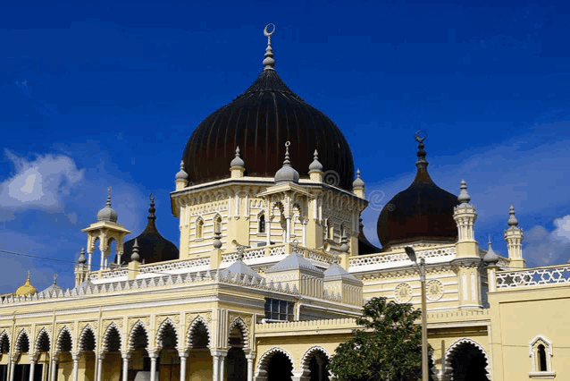 a large yellow building with a dome and a crescent moon on top