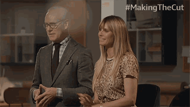 a man in a suit and tie stands next to a woman in a leopard print dress with the hashtag #making the cut