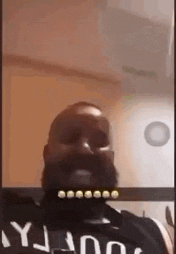 a man with a beard is taking a selfie with a camera .