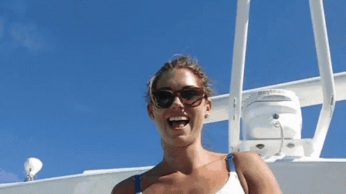 a woman wearing sunglasses is standing on a boat with a raymarine device in the background