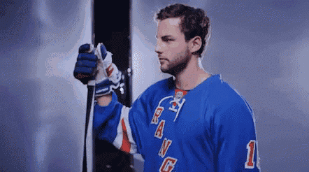 a hockey player is holding a hockey stick in his hand .