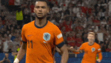 a soccer player in an orange jersey with the number 1 on the front