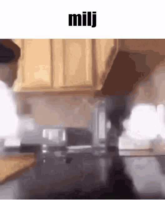 a man is standing in a kitchen with a stove top oven and smoke coming out of it .