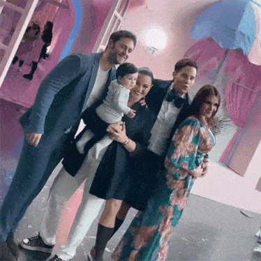 a group of people posing for a photo with a baby in the middle