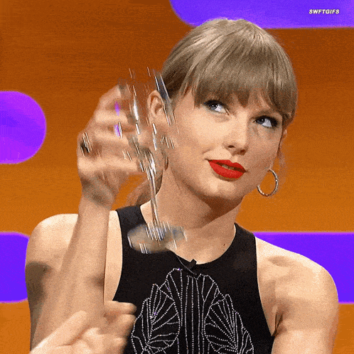 a woman in a black tank top is holding a glass of wine with the caption swftgifs