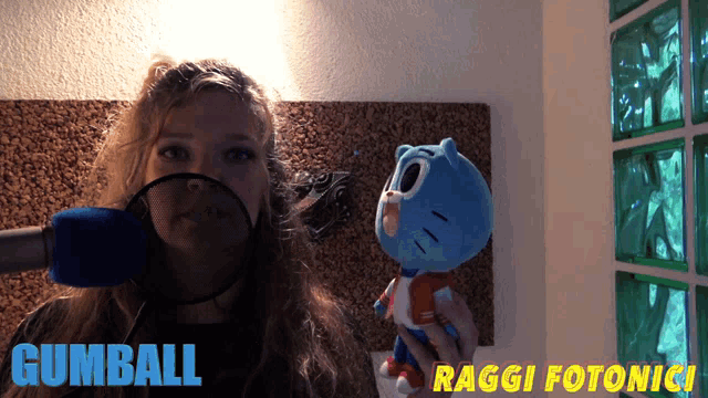 a woman is holding a stuffed animal with the name gumball written on it