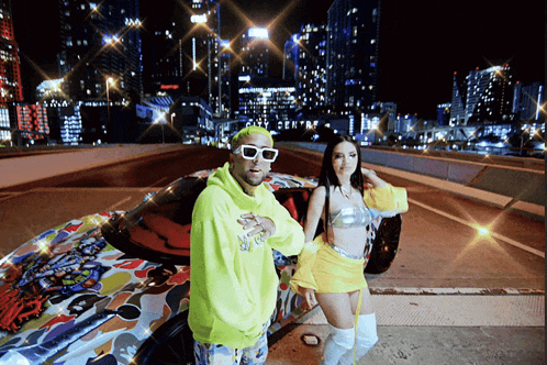 a man in a neon yellow hoodie stands next to a woman