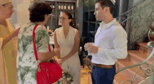 a man and a woman are standing next to each other in a room talking to each other .