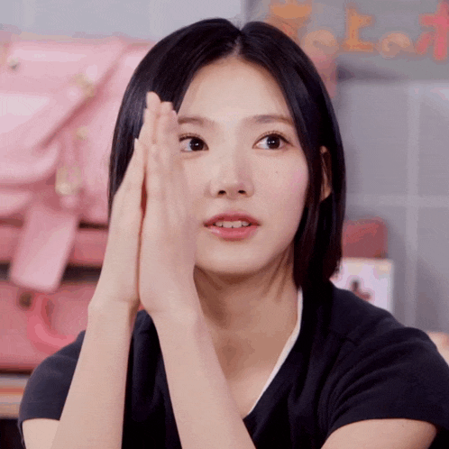 a close up of a woman 's face with her hands on her forehead