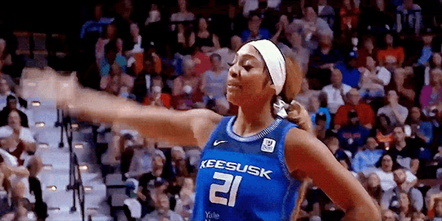 a female basketball player wearing a jersey with the number 21 on it