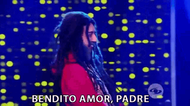 a man with dreadlocks and a beard is standing in front of a blue background and says bendito amor padre .
