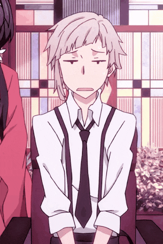 a man in a white shirt and tie is making a face