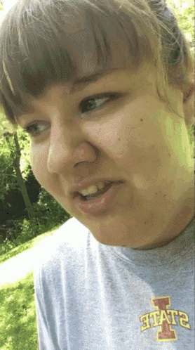 a woman wearing a gray shirt that says state on it