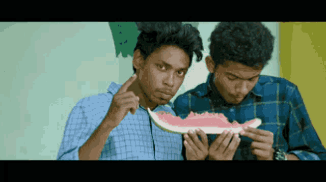 two young men holding a slice of watermelon
