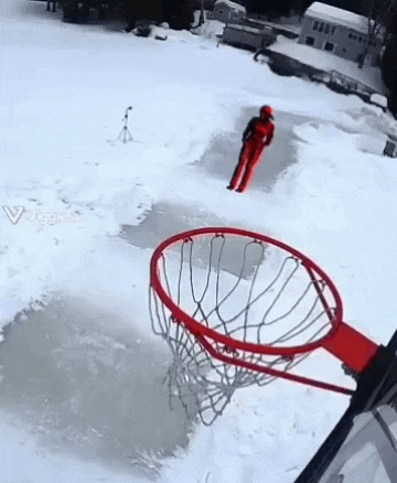 a person in a red suit is playing basketball in the snow