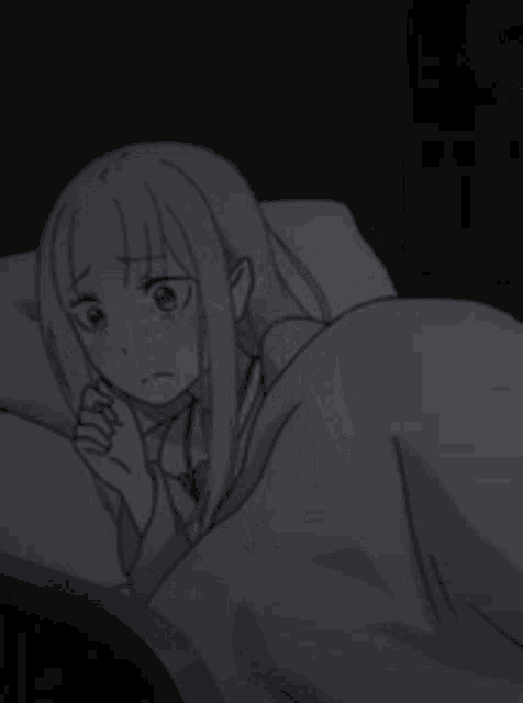 a girl is laying in a bed with a blanket on her .
