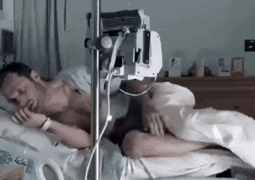 a man laying in a hospital bed with an iv