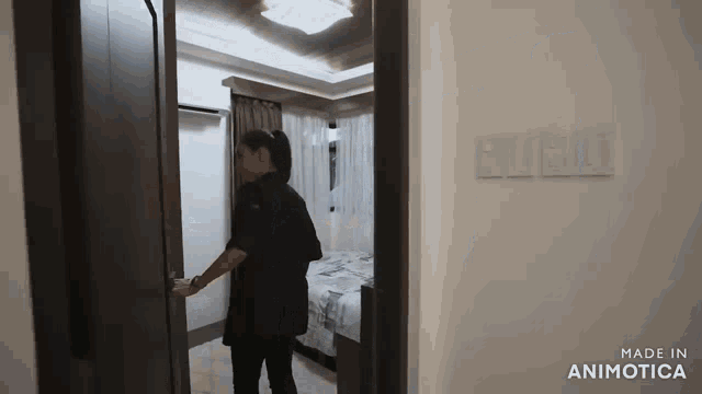 a woman opens a door to a bedroom with the word public written on the wall