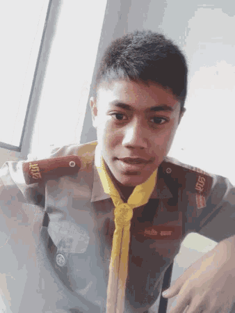 a boy in a uniform with a yellow scarf around his neck has a badge on his shoulder that says ' 007 '