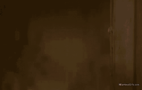 a man with a bloody head is peeking out from behind a door .