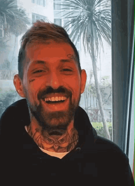 a man with a beard has a tattoo on his forehead that says q